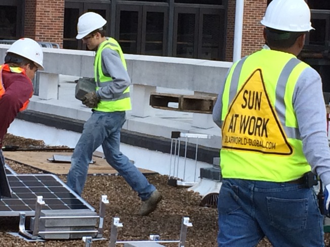 Workers install solar panels at the University of Richmond. 