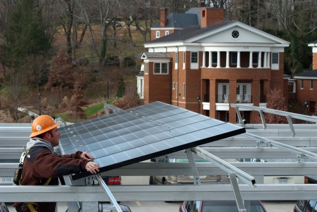 Worker installing solar panels on a roof.